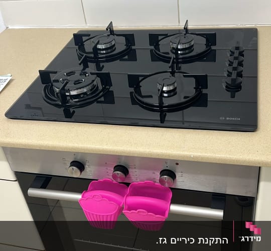 כיריים גז שחורות עם ארבעה מבערים ותנור אפייה מתחת
